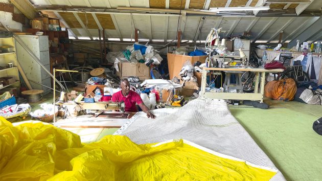 Someone sat in a St. Lucia sail loft with a bif sail on their lap