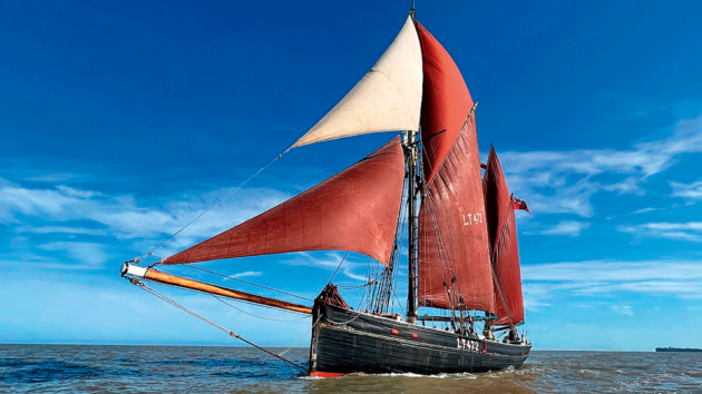 A large schooner with red sails